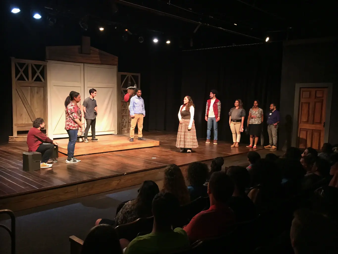 A diverse audience enjoying a performance in a community theater, highlighting the importance of cultural engagement and accessibility.